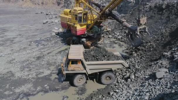 Mikashevichi, Belarus, 14.04.2020 - Big excavator loading granite into heavy dump truck High angle — 图库视频影像