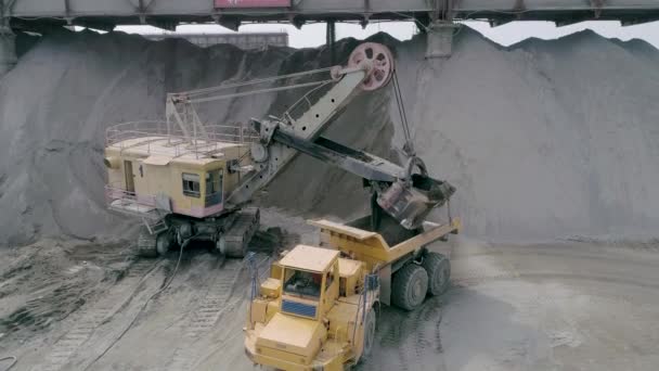 Mikashevichi, Belarus, 14.04.2020 - Heavy mining equipment excavators, large dump trucks, front loaders working on production of crushed stone, close up slow motion — 图库视频影像