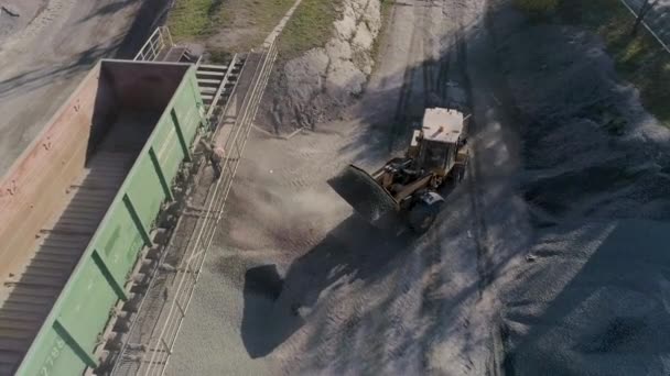 Cargador frontal carga grava en el cuerpo del camión de volteo en el centro logístico de la construcción — Vídeo de stock