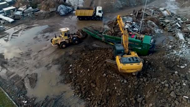 Minsk, Bielorrusia 13.04.2020 - reciclaje de equipos pesados de hormigón: cargadora frontal, excavadora, estación de trituración de concreto, camión volquete que trabaja en el reciclaje de residuos de construcción vista aérea — Vídeo de stock