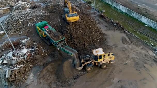 白俄罗斯明斯克，2020年4月13日-- --混凝土重型建筑设备的工业循环利用：前置装载机、挖掘机、从事建筑废物航空视图循环利用工作的混凝土破碎站 — 图库视频影像