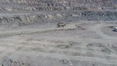 Büyük granit açık maden ocağında maden kamyonları. Taş ocağı yolunda yüklü kamyon gezintileri