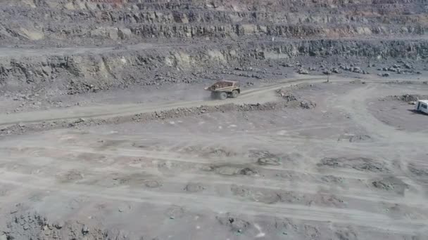 Camiones volquete mineros en gran mina de granito a cielo abierto. Paseos en camión cargados en carretera de repisa de cantera — Vídeos de Stock