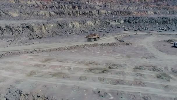 Exploitation de camions à benne dans une grande mine de granit à ciel ouvert. Balades en camion chargé sur le rebord de carrière de la route 