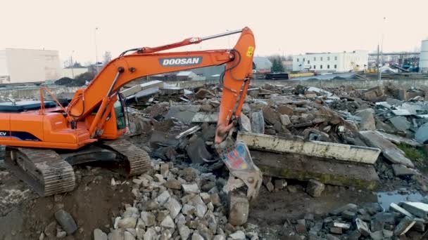 Minsk, Vitryssland 13.04.2020 - återvinning av betong, hydraulisk grävmaskin med käftkross i arbete, miljöskydd från föroreningar från byggavfall, drönarsikt — Stockvideo