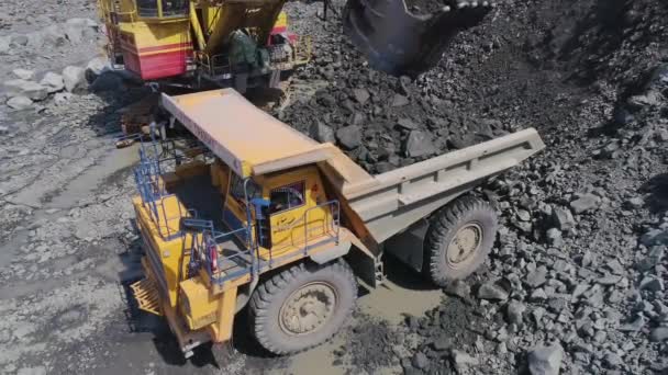 Mikashevichi, Belarus, 14.04.2020 - Large excavator loading granite into heavy dump truck High angle close up Belaz — 비디오