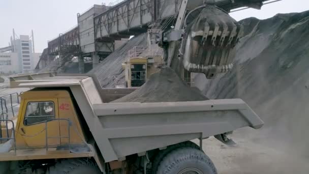 Michajeviči, Bělorusko, 14.04.2020 - Těžké těžební stroje, velké skládkové vozy, přední nakladače pracující na výrobě drcených kamenů, letecký pohled zblízka — Stock video