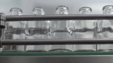 Tıbbi çözüm taşıyıcı hattındaki cam şişeler kapalı.