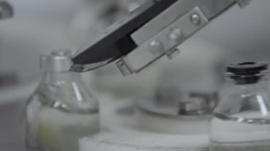 Tıbbi çözüm taşıma hattı alüminyum kaplama bölümündeki plastik kapaklarla doldurulmuş ve mühürlenmiş cam şişeler seçici odak noktasını kapatın