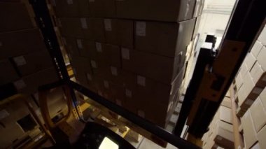 Forklift karton kutularla dolu paletleri taşır.