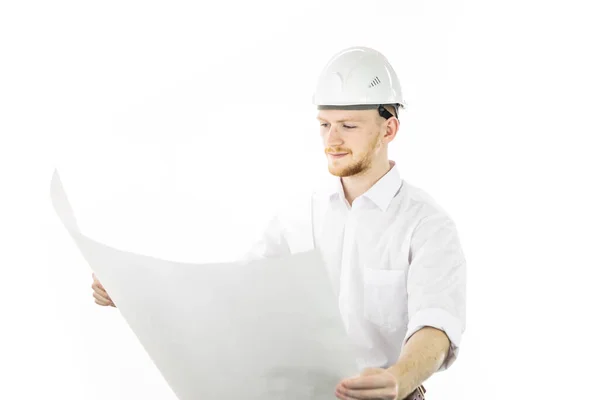 Zufriedener gutaussehender Ingenieur im Schutzhelm arbeitet mit Blaupausen-Dokumenten — Stockfoto