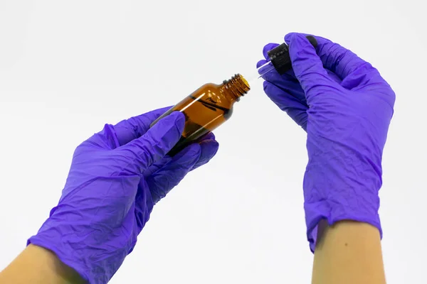 Zárja be az üveg kozmetikai edény terápiás komponensekkel a kezében kesztyűvel — Stock Fotó
