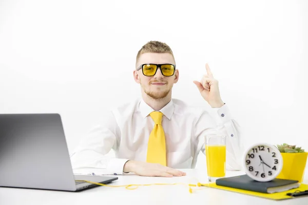 stock image manager with yellow glasses points his finger up, accent on yellow tie juice pot