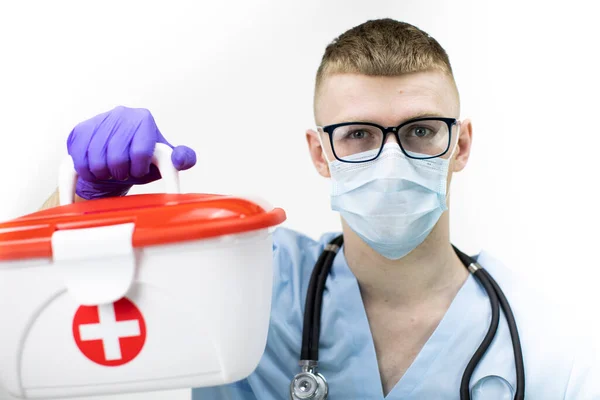 Paramédico en máscara protectora, gafas y guantes de látex azul sostiene caso médico —  Fotos de Stock
