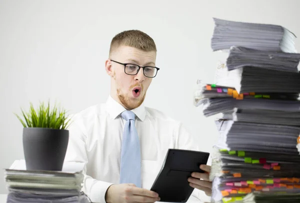 Trabalhador de escritório masculino chocado com papéis e calculadora contando dinheiro - orçamento — Fotografia de Stock