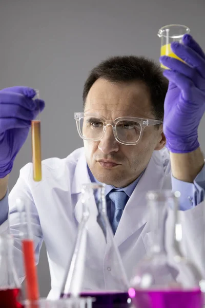 Wetenschapper werkt in het lab met reageerbuiskolven, voert wetenschappelijke experimenten uit — Stockfoto