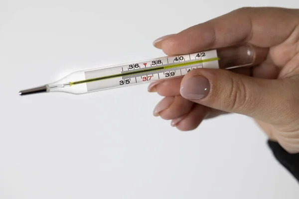 Termómetro médico de cerca en la mano femenina que muestra alta temperatura corporal — Foto de Stock