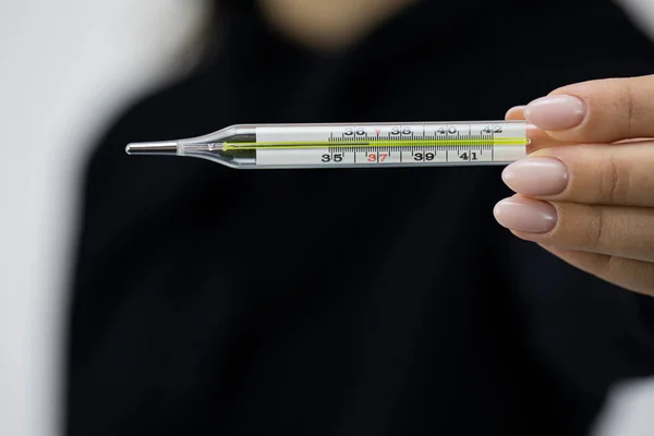 Termómetro de vidrio médico de mercurio en mano femenina que muestra 36,6 — Foto de Stock