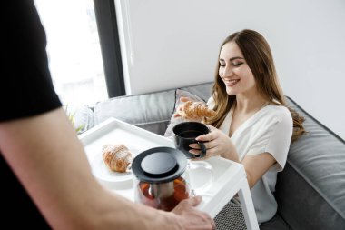 Genç Bir Kız Yatakta Kahvaltı Yapıyor. Fransız kruvasanı Tepside Çay