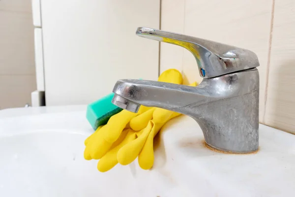 Esponja y guantes para lavar el grifo sucio con cal, grifo de agua calcificada con escala de cal en el lavabo en el baño, concepto de limpieza de la casa — Foto de Stock