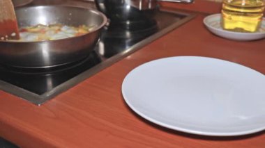 Bir şef buharda pişmiş omlet koyar, domatesli yumurta ve soğanı yakın çekime koyar.