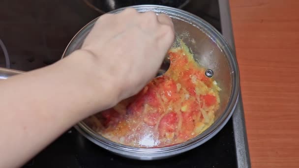Vaření rajčatová omáčka s nakrájenými rajčaty a cibulí v pánvi, šéfkuchař míchání s dřevěnou špachtle zblízka — Stock video