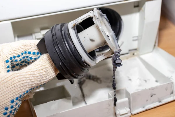 Ispezione filtro sporco della pompa di scarico intasato della lavatrice da vicino, pulire e riparare — Foto Stock