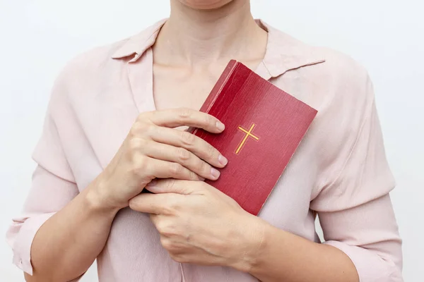 Joven orando las manos de la mujer cristiana sosteniendo la sagrada Biblia con una cruz en una cubierta — Foto de Stock