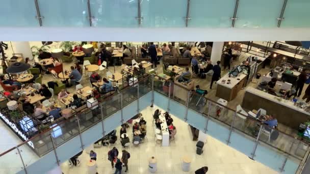 Moscow, Russia - November 13, 2019: A lot of people walking and sitting by the tables, eating in a cafe at foodcourt in shopping mall, center — Stock Video