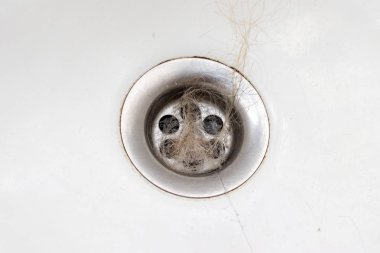 Tıkanmış kanalizasyon, tıkanmış banyo gideri dökülmüş saçlar yakın çekim, banyoda saç dökülmesi.
