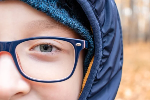 Μάτια ενός έξυπνου έφηβου αγοριού φορώντας μπλε μοντέρνα γυαλιά από κοντά, σε εξωτερικούς χώρους — Φωτογραφία Αρχείου