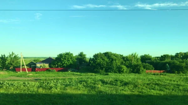 Вид, пейзаж з вікна рухомого поїзда з зеленим пейзажем, полями, пагорбами і селами — стокове фото