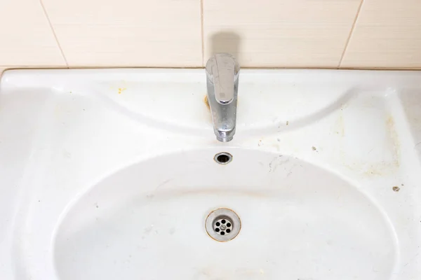Staré špinavé umyvadlo s rezavými skvrnami, vápencem a mýdlovými skvrnami v koupelně s kohoutkem, vodovodním kohoutkem — Stock fotografie