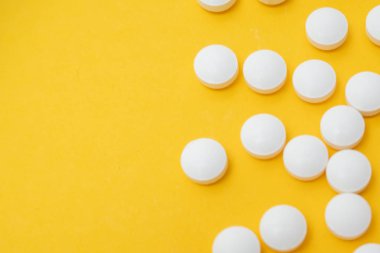 Birçok beyaz tablet sarı zemin üzerine kapanır. Fotokopi alanı, sonbahar ve kış viral hastalıkları, enfeksiyon