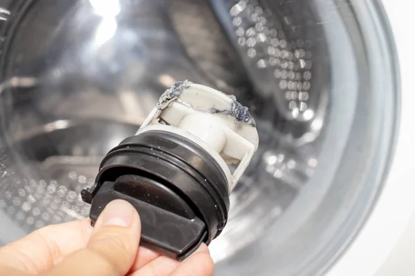 Inspecting washing machine's dirty clogged drain pump filter close up, clean and repair — Stock Photo, Image