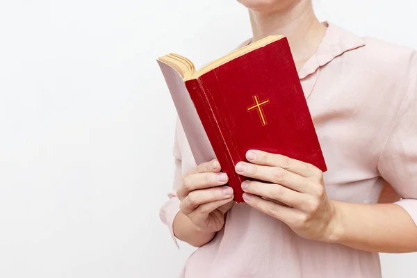 Joven orando las manos de la mujer cristiana sosteniendo la sagrada Biblia con una cruz en una cubierta — Foto de Stock