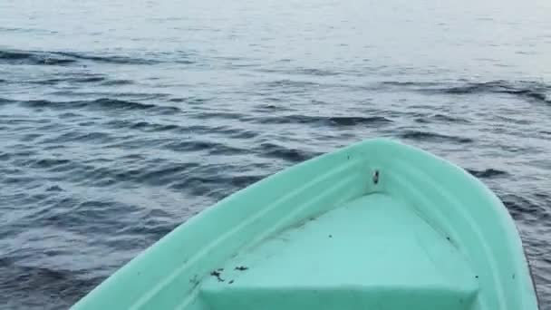 在海岸上的一艘渔船，平静的大海，背景上波涛汹涌 — 图库视频影像