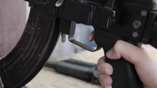 Caucasiano adolescente mira com rifle pneumático na galeria de tiro, alcance, puxando o gatilho de perto — Vídeo de Stock