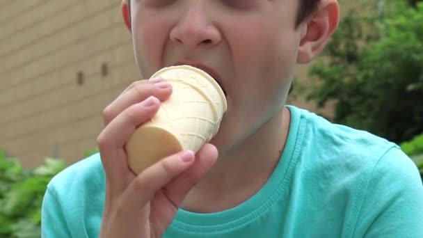 A portrait of a preteen boy eating icecream outdoors on summer day — Stock Video