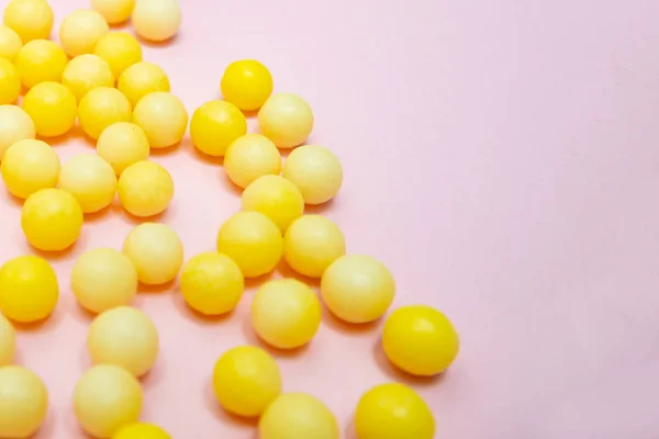 Dragoni rotondi colorati gialli di vitamina c, acido ascorbico su sfondo rosa, copiare spazio — Foto Stock