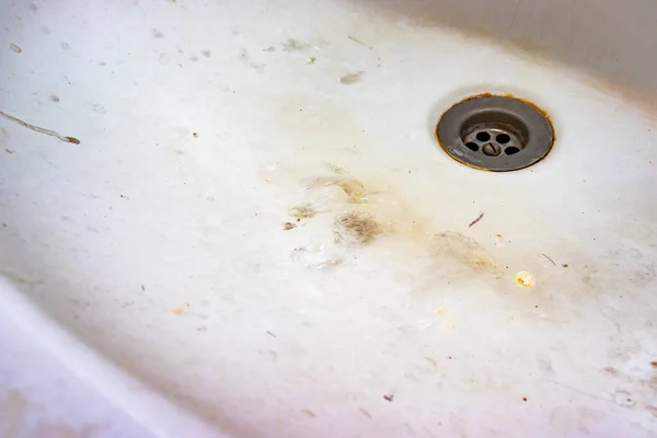 Un agujero de desagüe del fregadero con escala de cal o cal y óxido en él, sucio lavabo de baño calcificado oxidado con manchas de jabón — Foto de Stock