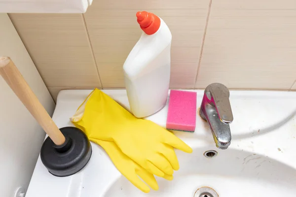 Cleaning products, agents, gloves plunger tj clean clogged sewer, drain and sponge for washing dirty faucet with limescale, calcified water tap with lime scale on washbowl in bathroom