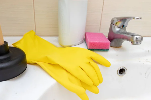 Schoonmaakmiddelen, agenten handschoenen en spons voor het wassen van vuile kraan met kalkaanslag, kalkhoudende waterkraan met kalkaanslag op waskom in badkamer — Stockfoto