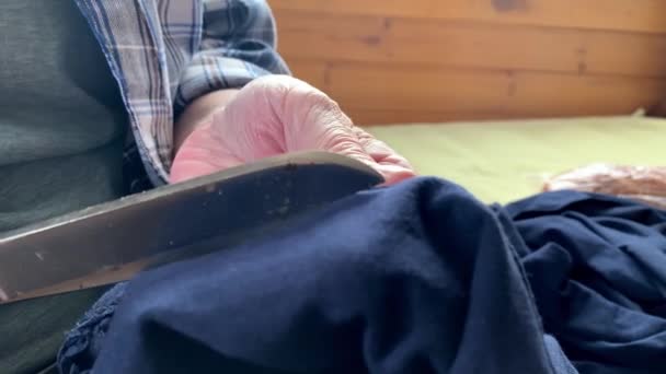 Een oudere vrouw oma snijden stof doek met een grote schaar om het te naaien, handen dicht — Stockvideo