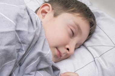 Ergen bir çocuk yatağında uyuyor, uyku saati ve tatlı rüyalar konsepti.