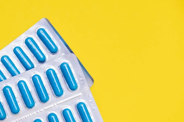 Dois pacotes de antibióticos, pílulas antivirais contra pneumonia e infecção bacteriana em fundo amarelo com espaço de cópia — Fotografia de Stock
