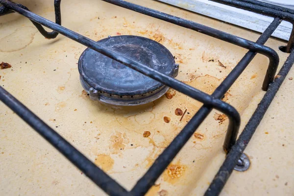 Dirty unhygienic surface of kitchen gas stove with grease and soot stains, close up