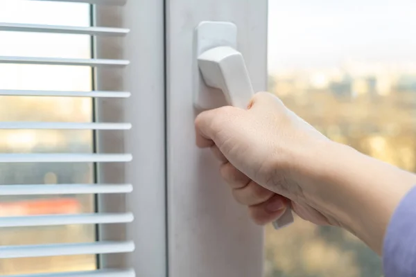 Mão abrindo uma janela de plástico para ar fresco na primavera — Fotografia de Stock