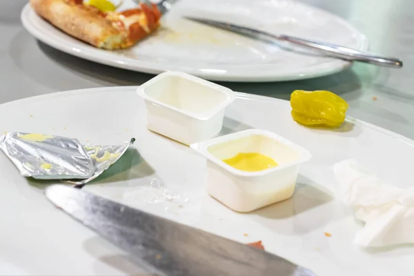 Mocskos tányérok ebéd után egy étteremben, maradékok és üres eldobható tartályok egy edényben — Stock Fotó