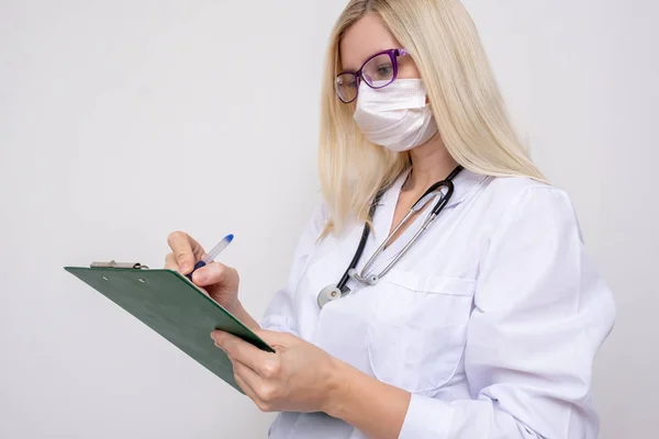 Mulher médica escrevendo na área de transferência um diagnóstico e prescrição após o exame de um paciente — Fotografia de Stock